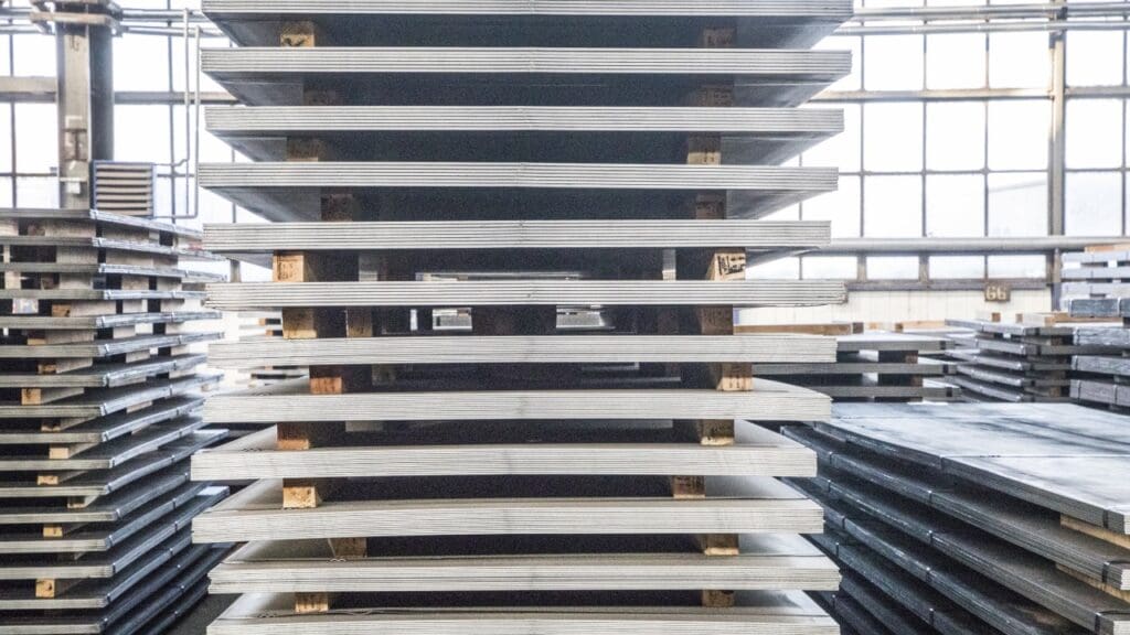 Stacked metal sheets in warehouse.
