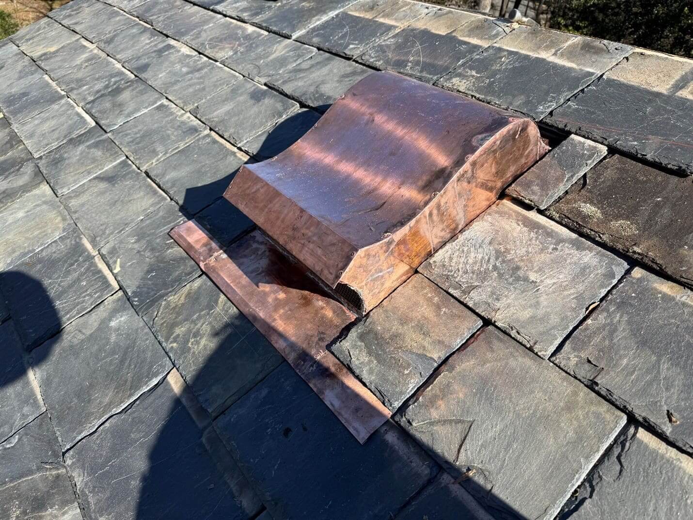 Copper vent on slate roof.