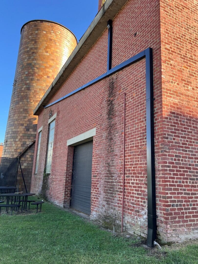 Brick building with round tower and grass.