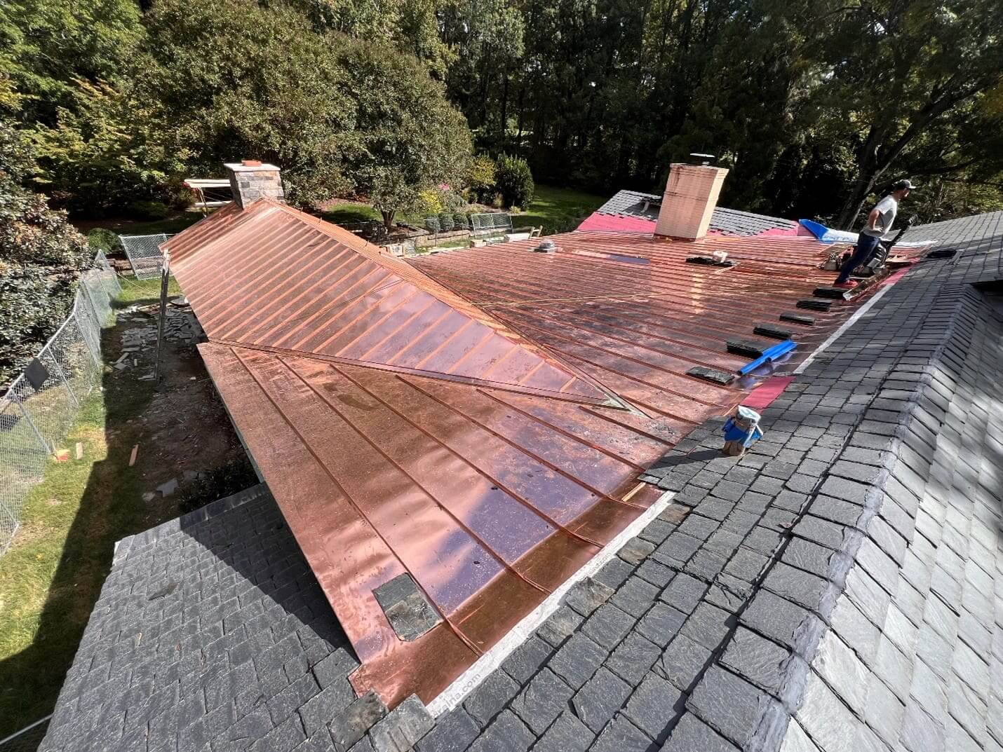 Copper roof installation in progress, sunny day.