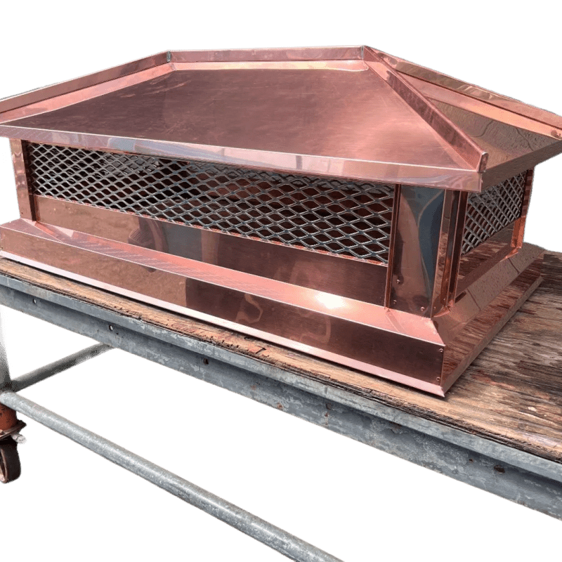 Copper chimney cap on wooden surface.