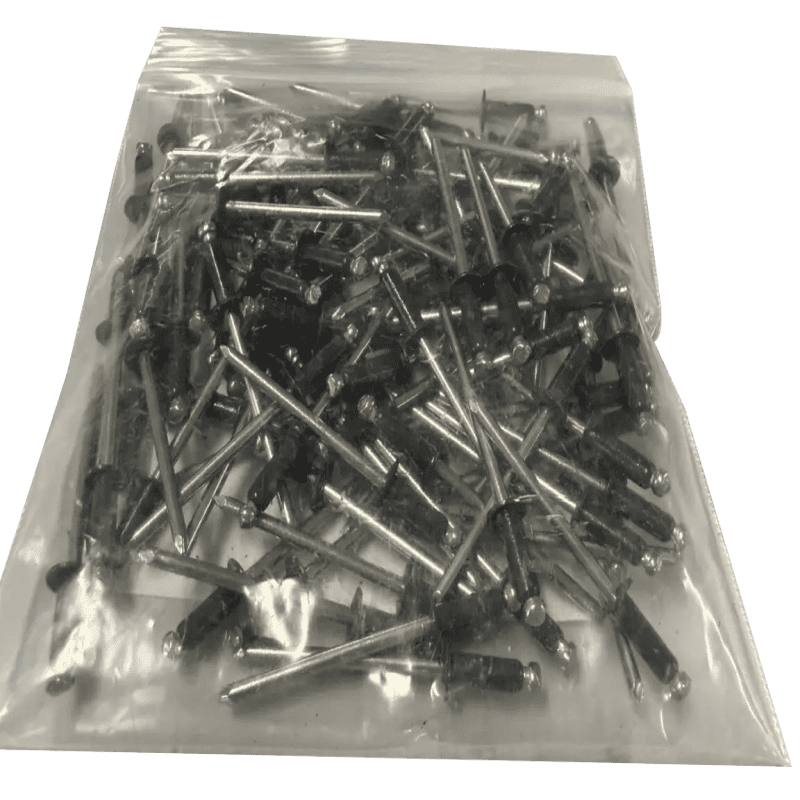 Bag of metal rivets on black background.